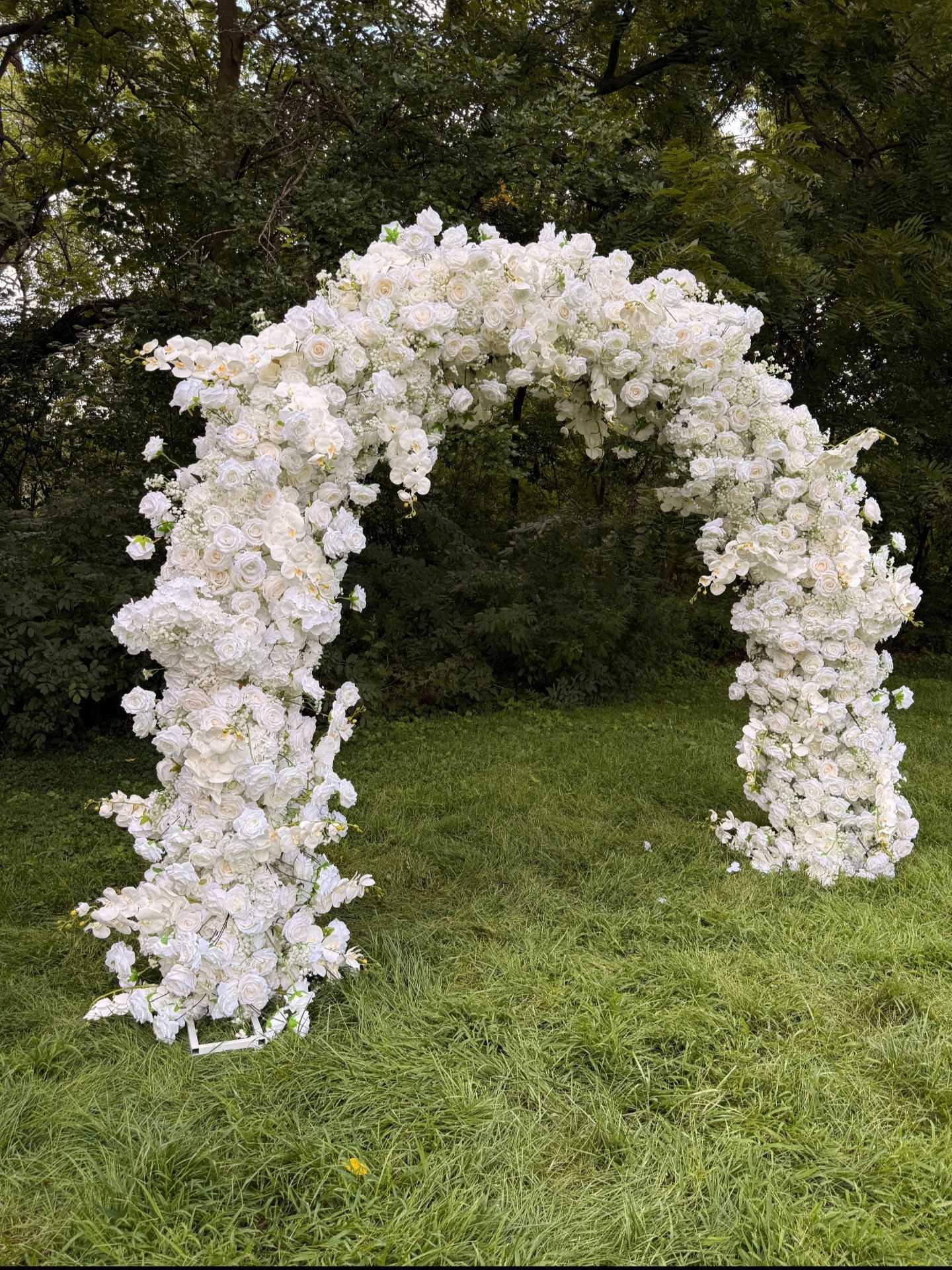 Guests posing under flower arch